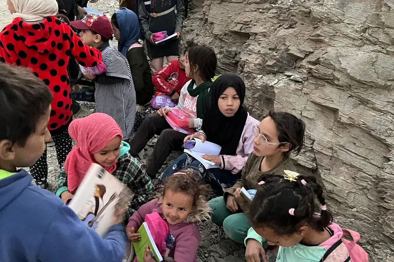 Children in a village in the High Atlas Mountains sitting with new backpacks and school kits